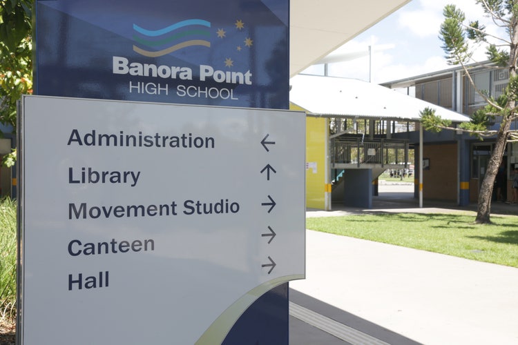 Sign with directional arrows to administration, library, movement studio, canteen, & hall.